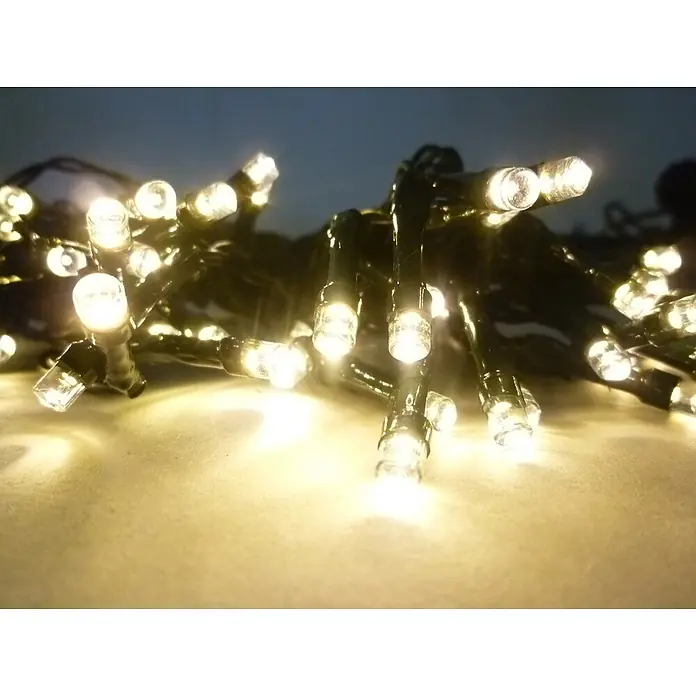 Solarlichterkette 48 LED warmweiß 14,5m -  - Helle, warmweiße LED-Lichterkette mit klaren Birnen und dunklen Kabeln, die ein sanftes Leuchten auf einer hellen Oberfläche erzeugt.