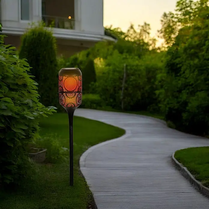 LED Solar-Wegeleuchte mit Flammeneffekt -  - Solar-Gartenfackel mit schwarzem Stab und zylindrischem Kopf, spendet orangefarbenes Flammenlicht am Weg.