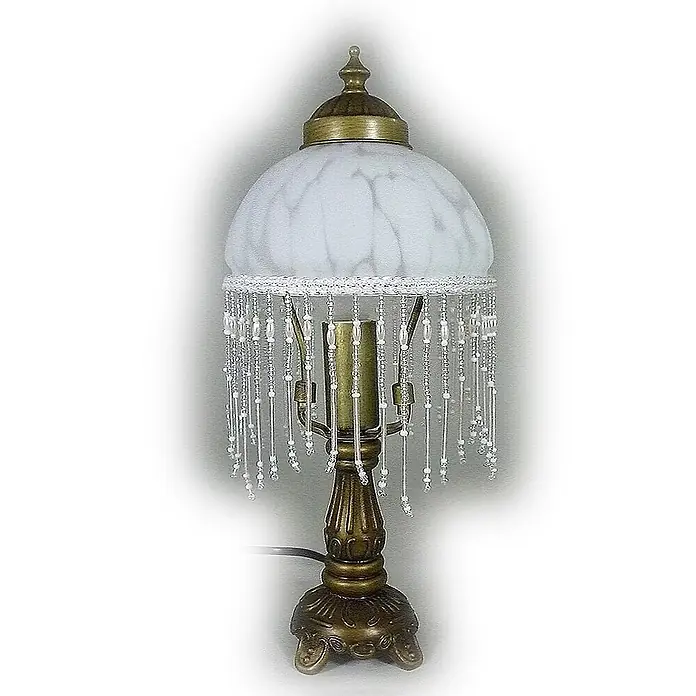Tischleuchte Weide Landhaus Stil messing -  - Eine Tischlampe im Antik-Stil mit Bronzefuß, mattiertem weißem Glasschirm und dekorativer Perlenfranse.