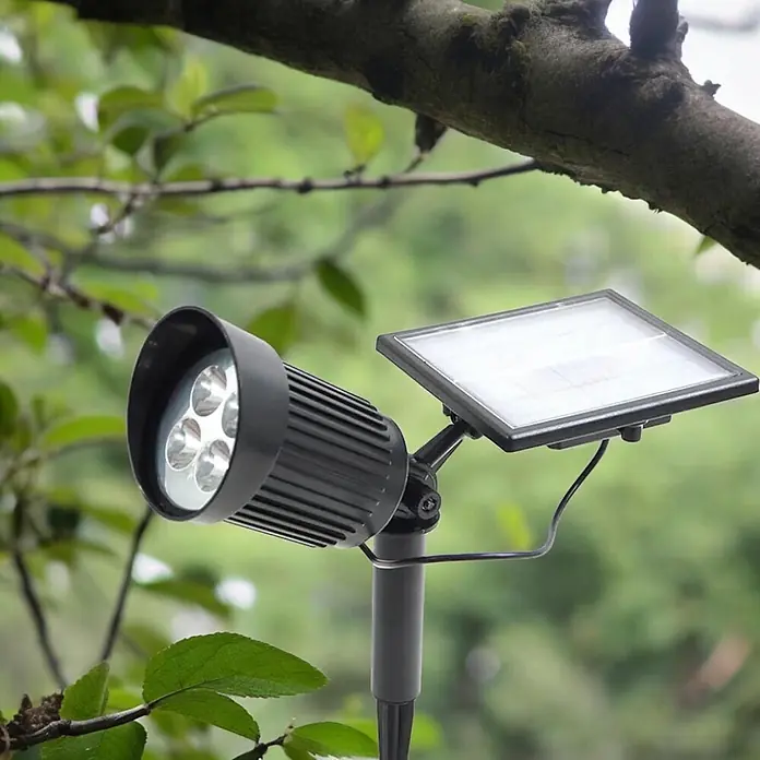 Solar Gartenstrahler Nelis mit 8LED 120lm -  - Schwarzer Solar-LED-Strahler mit vier LEDs und verstellbarem Solarpanel, draußen im Grünen.