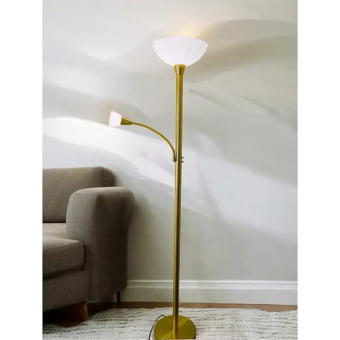 LED Stehleuchte Mattis messing mit Lesearm -  - Eine goldene Stehlampe mit Deckenfluter und flexibler Leselampe, die ein Wohnzimmer beleuchtet.