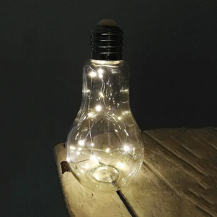 Dekoleuchte Tischlampe Glühbirne mit Lichterkette 20 LED batteriebetrieben -  - Eine klare Glaslampe in Glühbirnenform mit warmweißen Lichterketten auf rustikalem Holz.