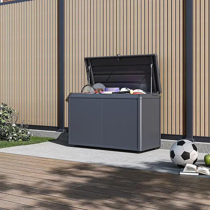 Weide Noble Gartenbox 290 L Stahl/Alu 1 m x 46 cm x H 64 cm Anthrazit -  - Dunkelgraue Outdoor-Aufbewahrungsbox mit offenem Deckel, gefüllt mit Sportgeräten, auf einer Terrasse.