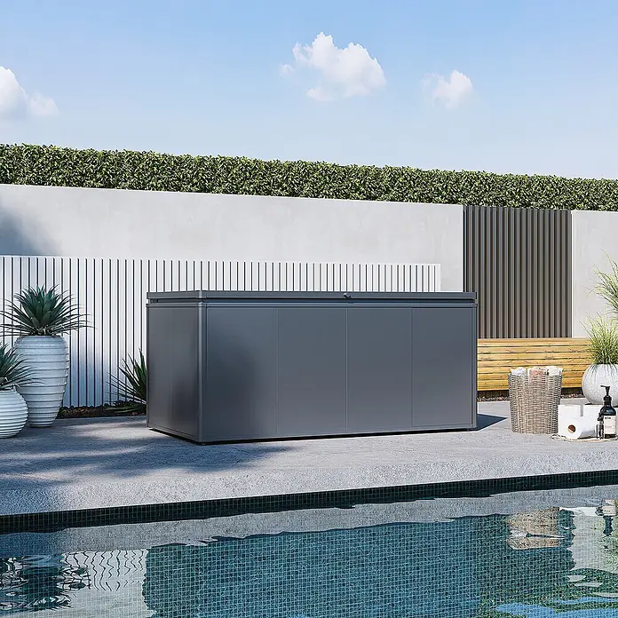 Weide Noble Gartenbox 1400 L Stahl/Alu 1,8 m x 95 cm x H 82 cm Anthrazit -  - Dunkelgrauer Outdoor-Stauschrank an einem Pool in einem modernen Garten.