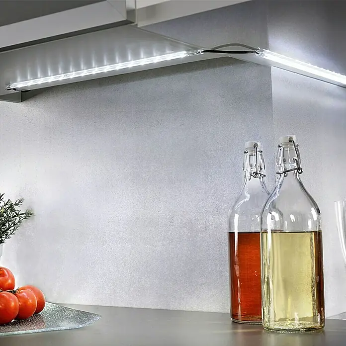 Tween Light Lichtleiste 4er Set - Länge: 160 cm, Lichtfarbe: Mehrfarbig, 0,15 W, Anzahl Leuchtmittel: 60 Stk. - LED-Leuchten unter dem Küchenschrank sorgen für eine helle Arbeitsfläche. Zwei dekorative Flaschen und frische Tomaten vervollständigen die Szene.