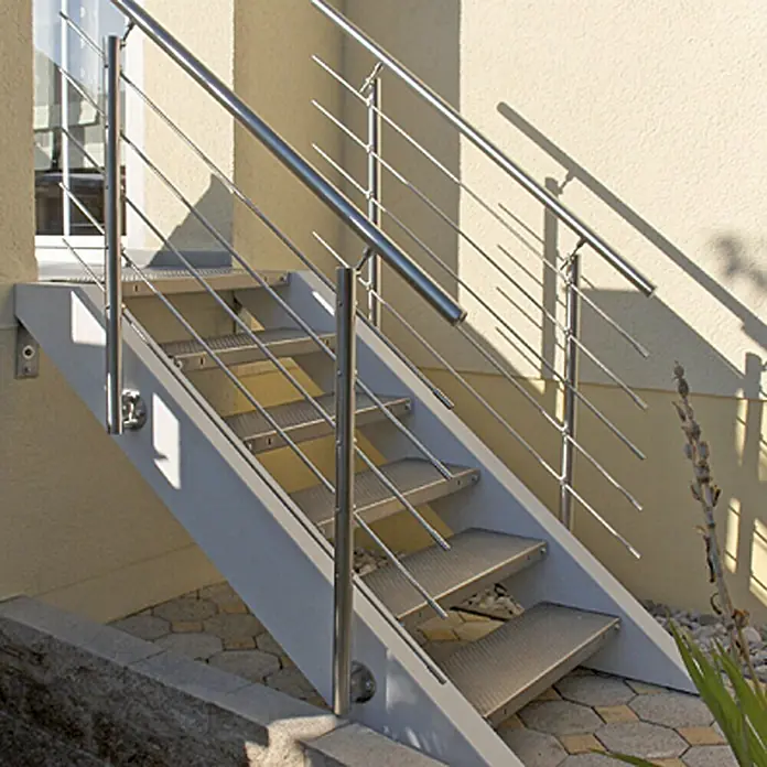 Treba Frewa Geländer-Set EG1 - Seitenmontage, Edelstahl V2A, Silber, Länge: 150 cm - Diese Aufnahme zeigt eine Außentreppe aus Metall mit Geländer, die zu einem Gebäude führt. Das Design ist modern und funktional.