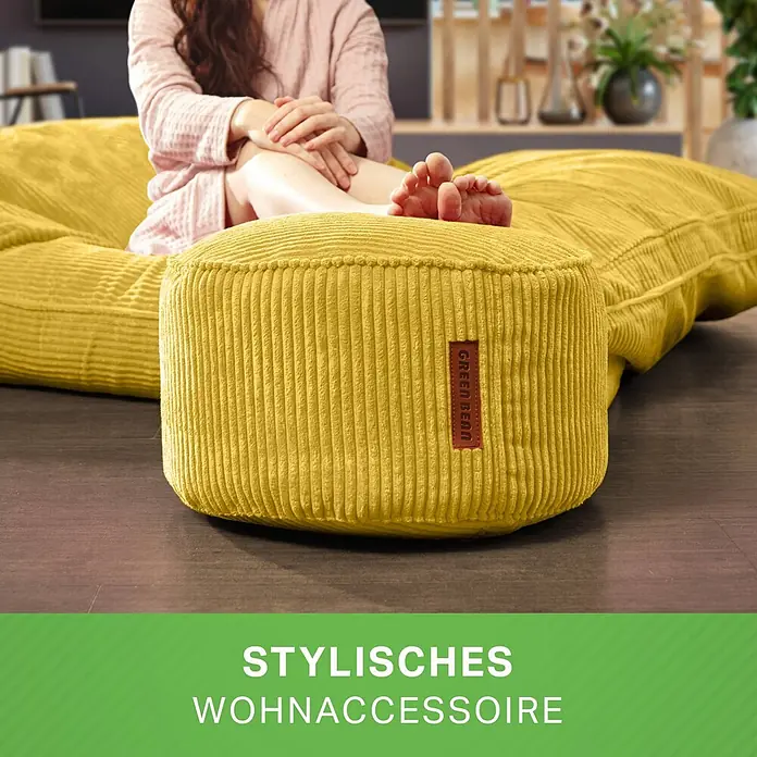 Green Bean Sitzhocker Pouf Cord mit EPS Füllung 45x25 cm Gelb -  - Ein gelber Cord-Pouf, Teil eines passenden Sitzsack-Sets, dient einer entspannten Person im Wohnzimmer als bequeme Fußstütze.