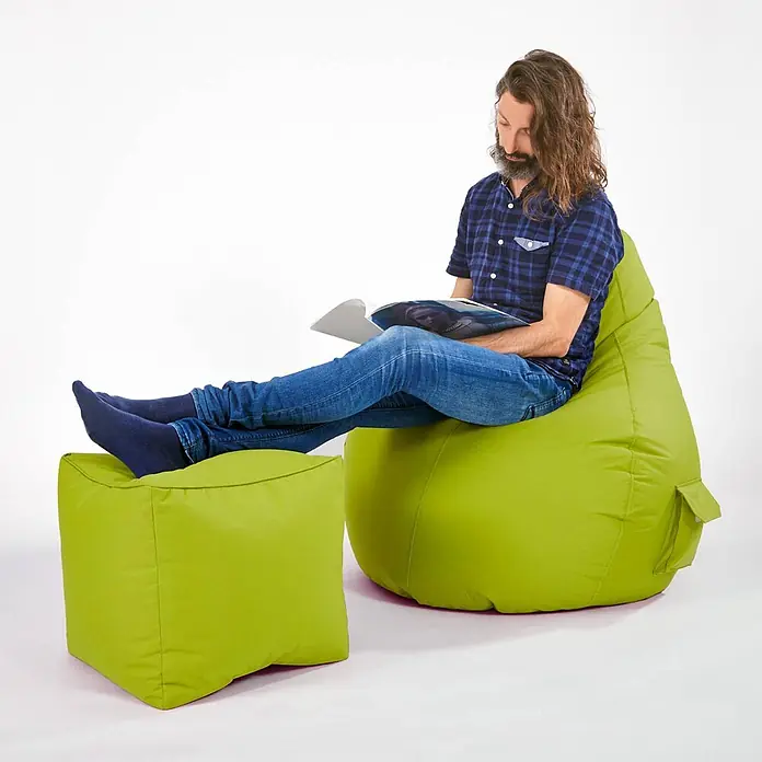 Green Bean Sitzhocker Cube mit EPS Füllung 40x40x40 cm Grün -  - Mann entspannt auf einem limettengrünen Sitzsack mit passendem Hocker und liest.