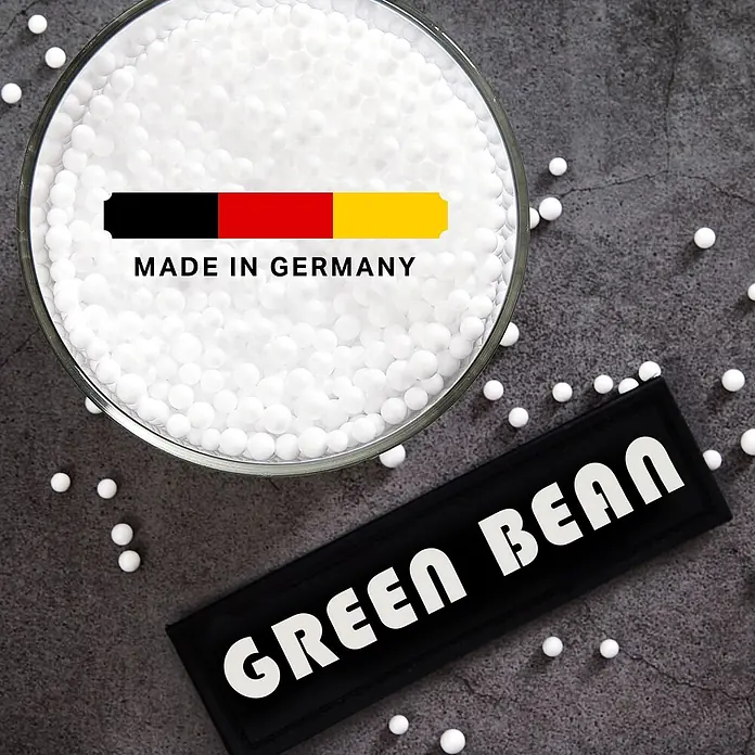 Green Bean EPS Perlen Sitzsack Füllung Nachfüllpack 1 L -  - Weiße kugelförmige Pellets in Glasschale mit „Made in Germany“-Etikett und „Green Bean“-Patch.