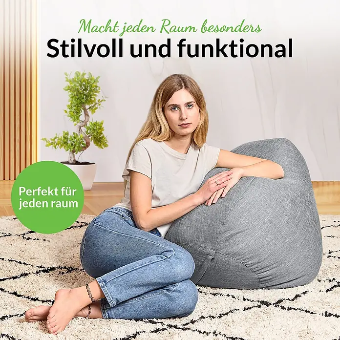 Green Bean Sitzsack Set Home Linen XXL mit Hocker 2 tlg. Silbergrau -  - Eine Frau sitzt bequem auf einem großen grauen Sitzsack in einem modernen Wohnzimmer.