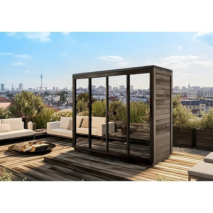 Gartensauna Kuuma L black mit Spiegelglas242x111cm Schwarz 42mm -  - Stilvolle Außensauna aus dunklem Holz und Glas auf einer Dachterrasse, umgeben von Loungemöbeln.