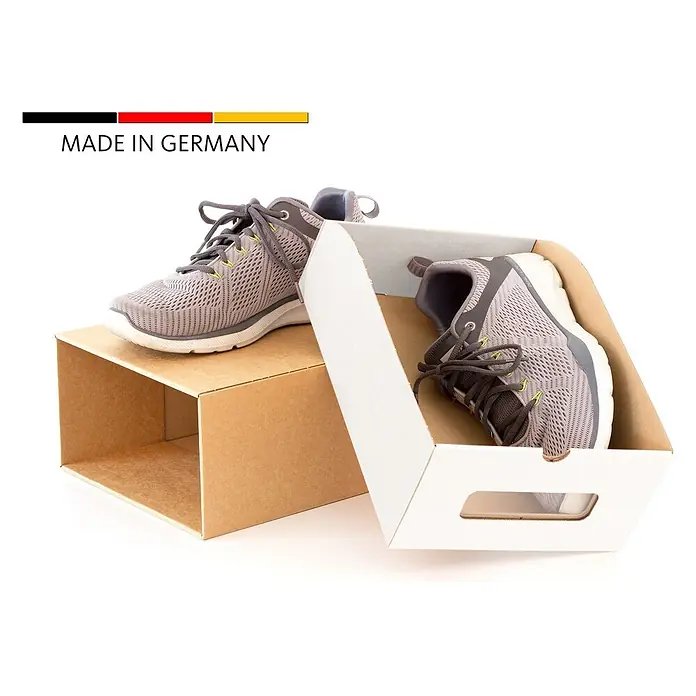 BigDean 10er Boxen Set Schuhbox, Braun -  - Ein Paar graue Sportschuhe, einer auf einem braunen Karton, der andere in einer weißen Box. „MADE IN GERMANY“ Flaggenetikett.
