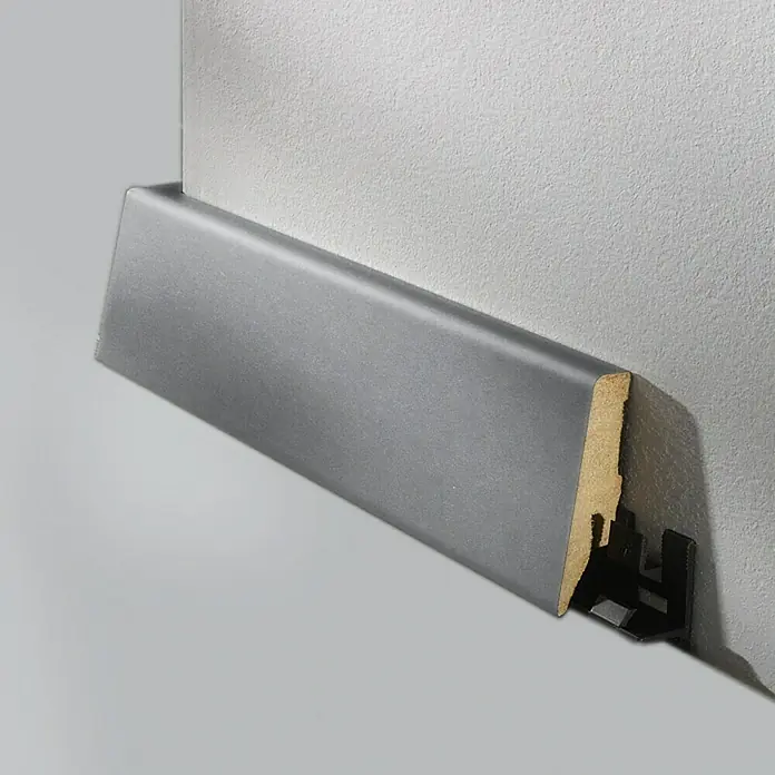 LOGOCLIC Sockelleiste K58 D Edelstahl matt - 260 cm x 19 mm x 58 mm, MDF - Nahaufnahme einer grauen Fußleiste mit einem braunen Holzkern und einer schwarzen Kunststoffbefestigung an einer Wand.