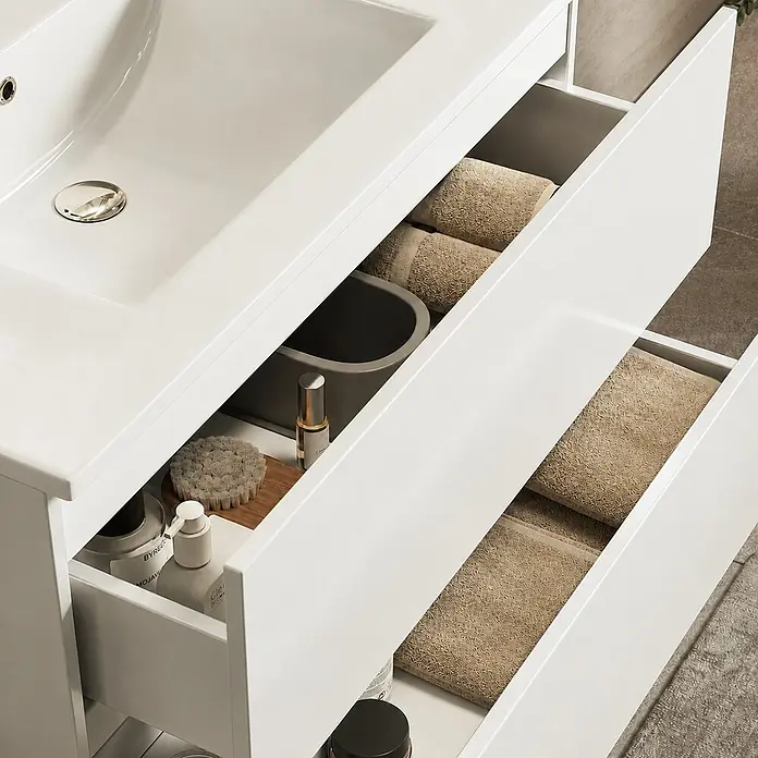LOMAZOO Badmöbel Nineo 80 cm Weiß glänzend, Waschbecken Weiß -  - Weißer Badunterschrank mit integriertem Waschbecken und offenen Schubladen, die beige Handtücher und Pflegeprodukte zeigen.