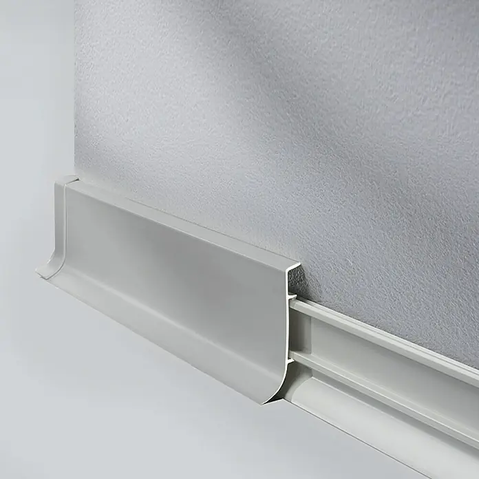 LOGOCLIC Sockelleiste KSL - 250 cm x 18,5 mm x 60 mm, Grau - Graue Fußleiste an einer grauen Wand befestigt, die einen sauberen und modernen Übergang zwischen Wand und Boden schafft.