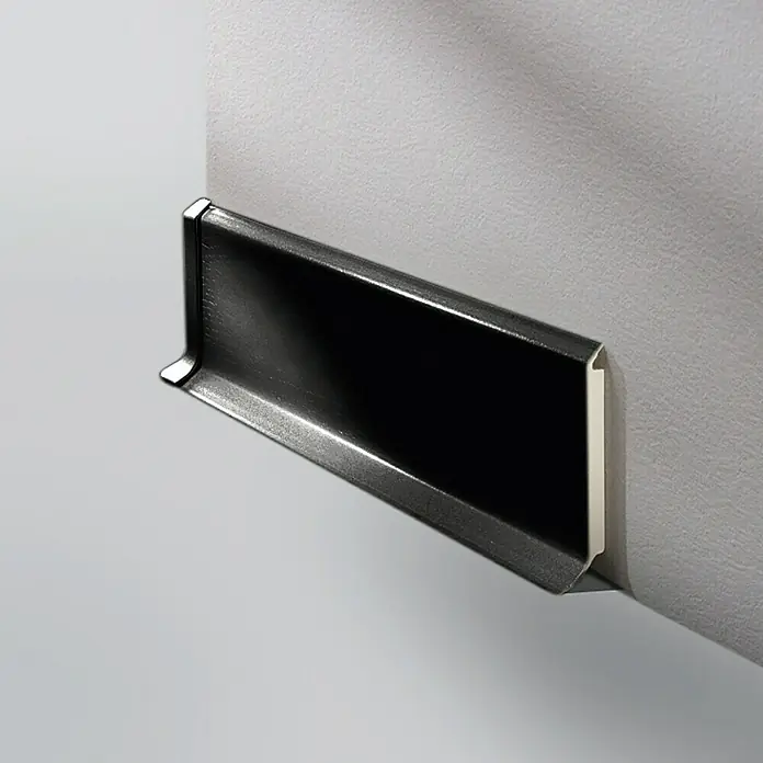 LOGOCLIC Sockelleiste HSL - 250 cm x 14 mm x 60 mm, Hartschaum, Schwarz - Nahaufnahme einer schwarzen Fußleiste an einer hellgrauen Wand, die das elegante Design und die Materialbeschaffenheit hervorhebt.
