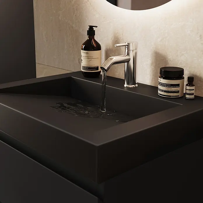 LOMAZOO Badmöbel Zarivo 60 cm Schwarz matt, Waschbecken Schwarz -  - Mattschwarzes Waschbecken mit Chromarmatur, aus der Wasser fließt, und Aesop-Produkten auf der Ablage.