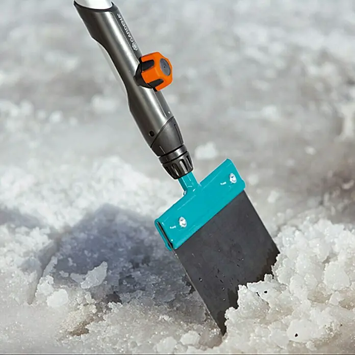 Gardena Combisystem Stoßscharre - Breite: 15 cm, Material Gerätekopf: Aluminium - Nahaufnahme eines Gardena Eisschabers im Einsatz, der Eis und Schnee entfernt. Praktisches und effizientes Werkzeug für den Winterdienst.