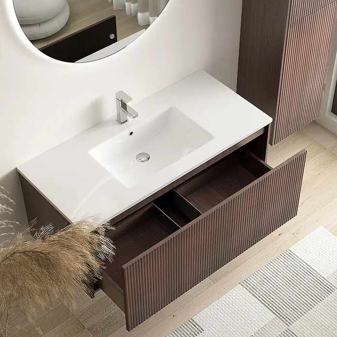 LOMAZOO Badmöbel Sovina 100 cm Nussbaum Rillenfront, Waschbecken Weiß -  - Dunkelbrauner, geriffelter Holz-Badunterschrank mit integriertem weißen Waschbecken, silbernem Wasserhahn und offener Schublade.
