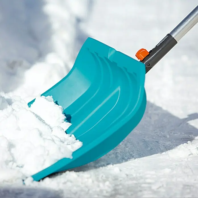 Gardena Combisystem Schneeschieber ES 50 - Breite: 50 cm, Aluminiumkante - Nahaufnahme einer hellblauen Schneeschaufel mit Aluminiumstiel, die mit Schnee gefüllt ist, ideal für Winterarbeiten.