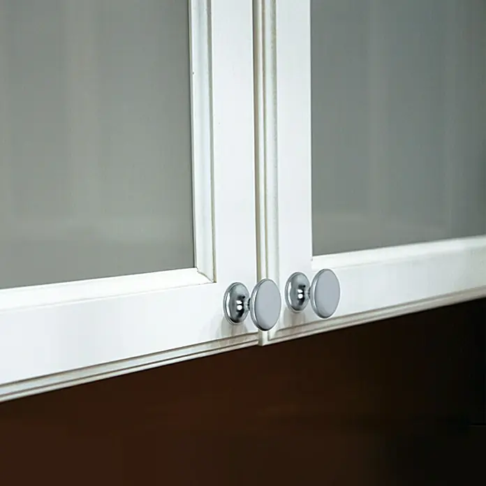 Möbelknopf - Typ Möbelgriff: Knopf, Ø x H: 33 x 27 mm, Sonstige, Vernickelt, Nickel - Nahaufnahme von weißen Glasschranktüren mit runden, silbernen Knöpfen. Das Design ist modern und minimalistisch.