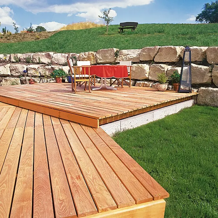 Konstruktionsholz - 200 x 7 x 4,5 cm, Douglasie - Bild einer Holzterrasse mit Gartenmöbeln, umgeben von üppigem Grün. Die Terrasse lädt zum Verweilen im Freien ein.