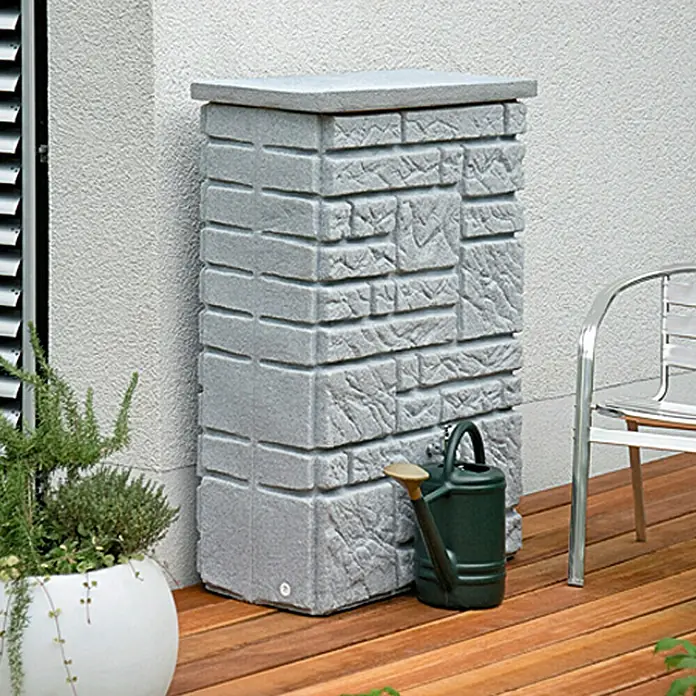 Arves Regenspeicher Maurano - 300 l, Granitfarben, 1 Stk. - Der stilvolle Steinoptik-Regenspeicher mit einer grünen Gießkanne davor, perfekt für die Gartenbewässerung und die Regenwassernutzung.