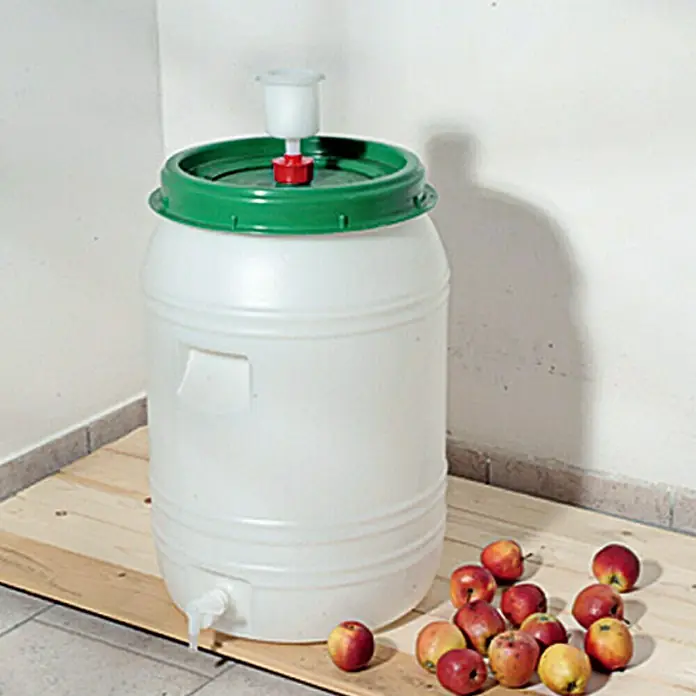 Floraworld Classic Getränkefass - 60 l - Fass mit grünem Deckel und Gärspund für die Weinherstellung, umgeben von Äpfeln.