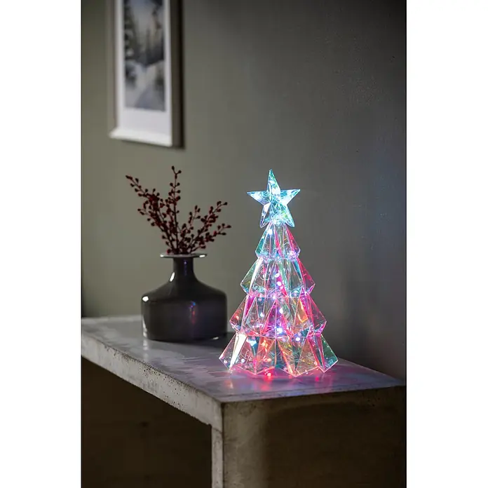 Konstsmide LED-Weihnachtsbaum - B x H: 24 x 30 cm, Lichtfarbe: RGB, Batteriebetrieben - Ein irisierender, facettierter LED-Weihnachtsbaum mit Sternspitze beleuchtet ein Betonregal.