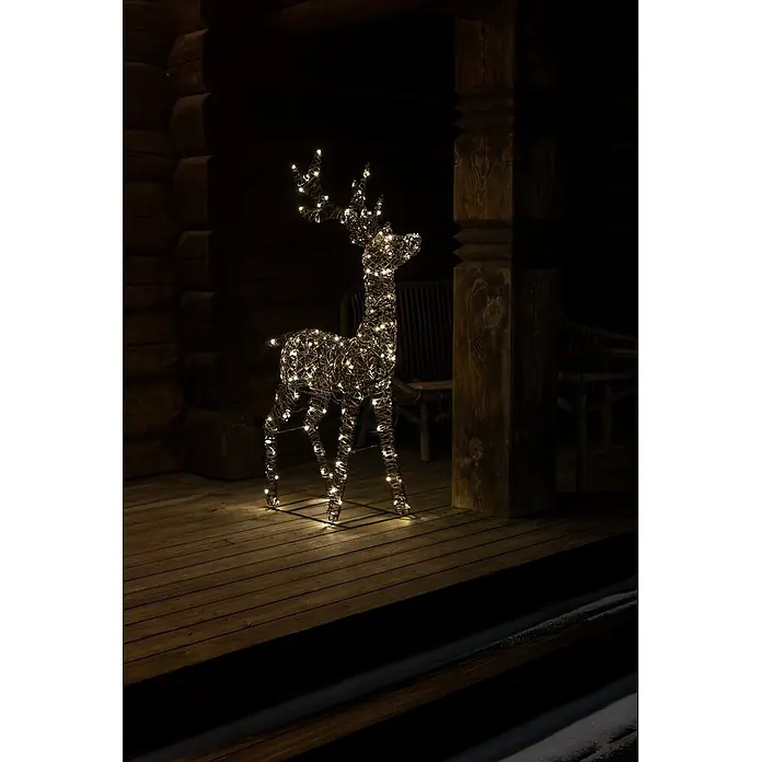 Konstsmide LED-Weihnachtsdekofigur Rentier - B x H: 80 x 130 cm, Braun, Warmweiß, LED - Beleuchtete Rentierfigur aus Korbflechtmaterial, nachts auf einer Holzveranda als Weihnachtsdekoration.