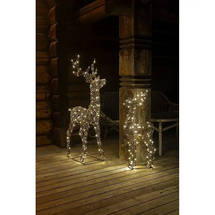 Konstsmide LED-Weihnachtsdekofigur Rentier - B x H: 80 x 130 cm, Braun, Warmweiß, LED - Zwei leuchtende Rentierfiguren aus geflochtenem Material stehen auf einer Holzterrasse und schmücken den Außenbereich festlich.
