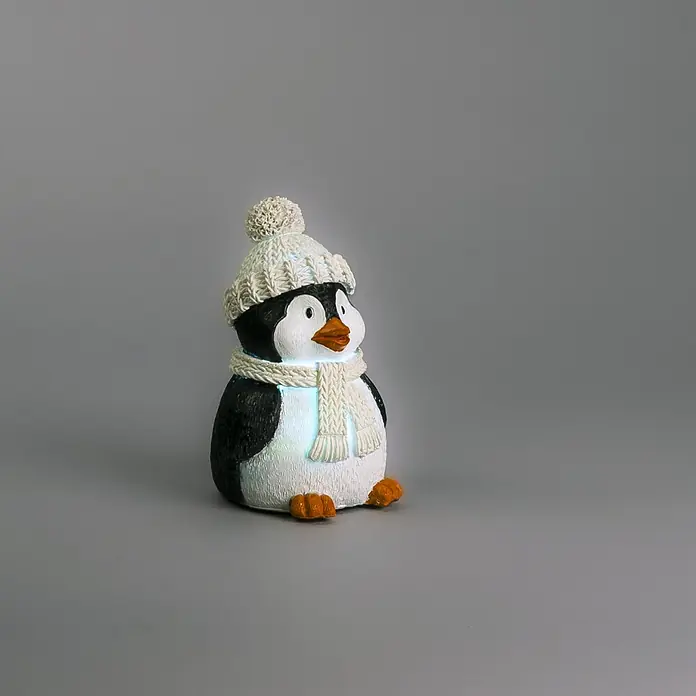 Konstsmide LED-Weihnachtsdekofigur - B x H: 9,5 x 15,5 cm, Lichtfarbe: RGB, Batteriebetrieben, LED - Leuchtende Pinguinfigur in Schwarz-Weiß mit orangefarbenem Schnabel und Füßen, trägt eine gestrickte cremefarbene Mütze und Schal.