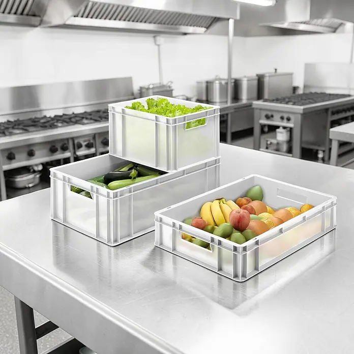 BAUHAUS Eurobox - 44 l, L x B x H: 60 x 40 x 22 cm, Geschlossen, Transparent - Weiße Kunststoffkisten mit frischem Obst und Gemüse auf einer Edelstahlarbeitsplatte in einer Großküche.