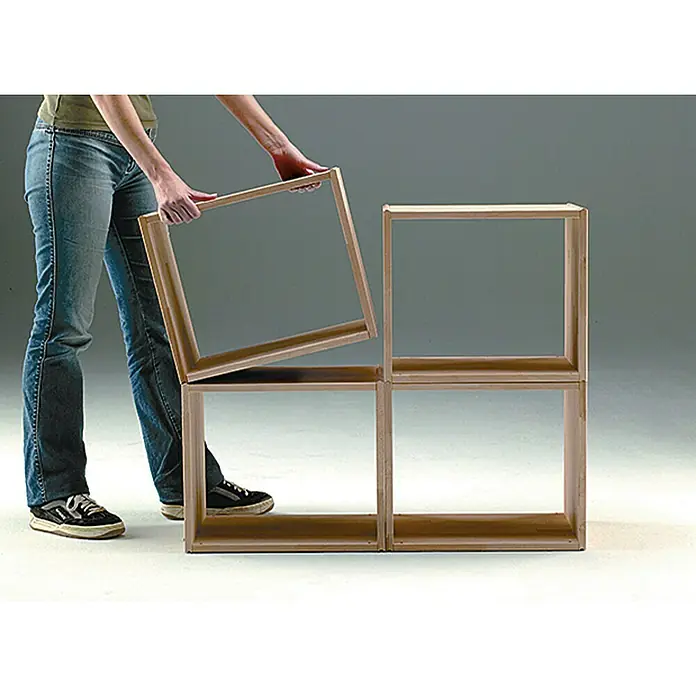 Regalux Regaltür & Rückwand-Set - 41,5 x 34,5 cm, Nadelholz - Ein modulares Holzregalsystem, das aus einzelnen Würfeln besteht, wird von einer Person zusammengesetzt.