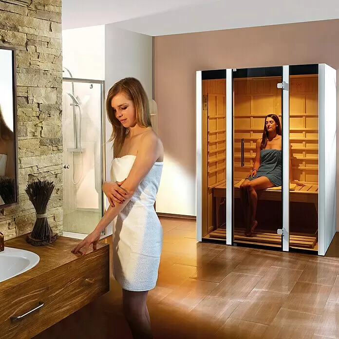 Weka Infrarotkabine Osby 1 - 140 x 99 x 190 cm - Moderne Indoor-Saunakabine mit Holzausstattung und Glastüren, in einem modernen Badezimmer in Gebrauch.