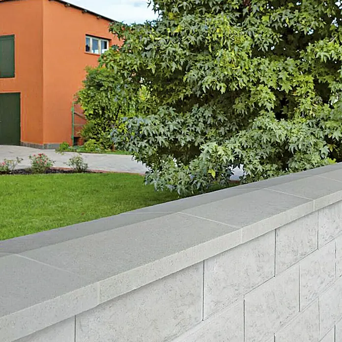 Mauerabdeckplatte Satteldach - Grau/Anthrazit, 50 x 25 cm, Beton - Nahaufnahme einer grauen Betonsteinmauer mit Decksteinen, die sich ideal für die Gartengestaltung eignet.