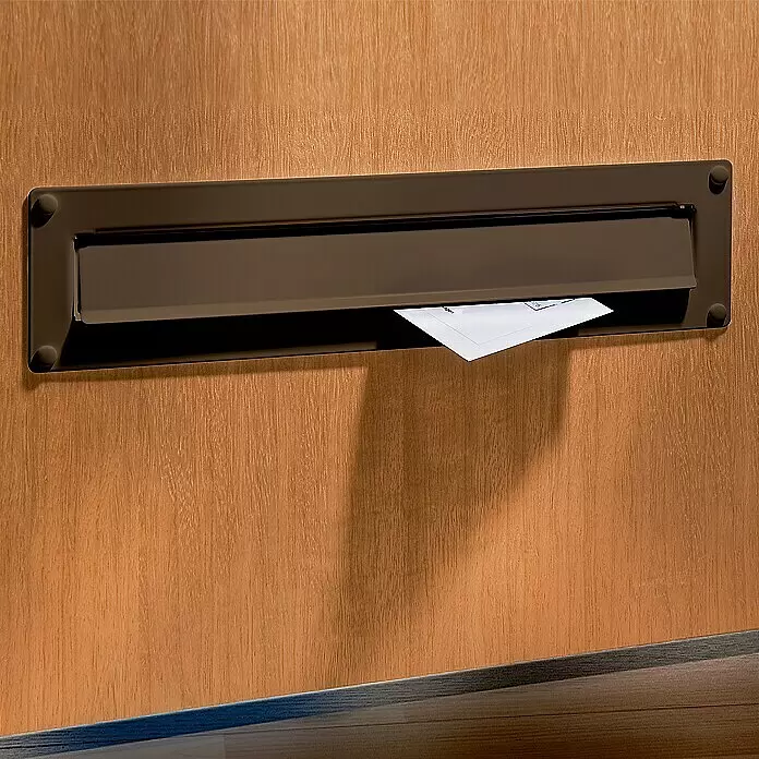 Burg-Wächter Einwurfblende Porta 796 - 304 x 101 mm, Aluminium, Braun - Dunkler Metall-Briefschlitz an einer Holztür mit einem Brief darin.