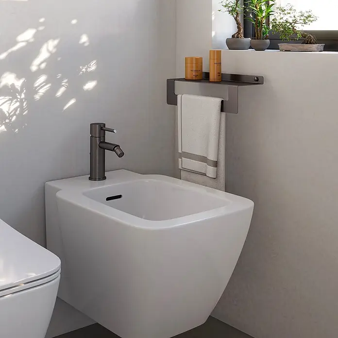 KV Duschablage mit Handtuchhalter 30 cm gun metal | Camelia -  - Weißes wandhängendes Bidet mit dunkler Metallarmatur in einem modernen Badezimmer. Handtuch und Pflegeprodukte auf einem Regal.