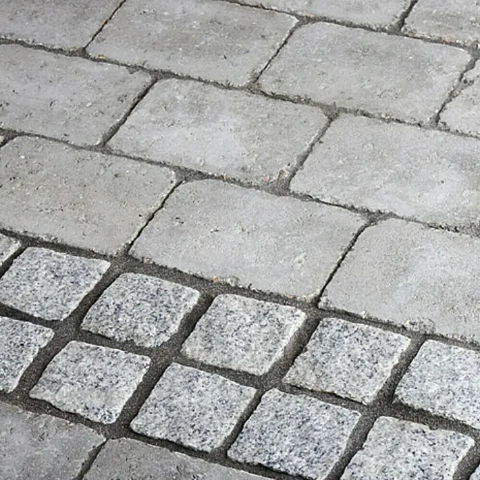 Dansand Fugenmörtel No Grow - Anthrazit, 20 kg - Nahaufnahme von hellgrauem Pflasterstein, der für Außenbereiche verwendet wird, mit deutlichen Texturdetails und Fugenlinien.