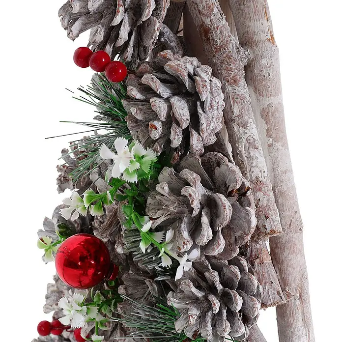 Mendler Deko-Weihnachtsbaum HWC-M17 Kiefernzapfen Holz 60x32x17cm -  - Nahaufnahme einer festlichen Dekoration mit beschneiten Tannenzapfen, roten Beeren, einer roten Kugel, Kunstgrün und weißen Blüten an weiß getünchten Ästen.