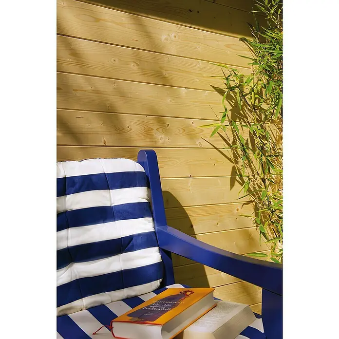 Kiehnholz Caseta de jardín Mikka - Medidas ext. (An x Pr): 228 x 233 cm, Madera, Natural, Tejado a dos aguas - Muebles de jardín con tapicería a rayas azules y blancas y un libro, sobre una pared de madera.