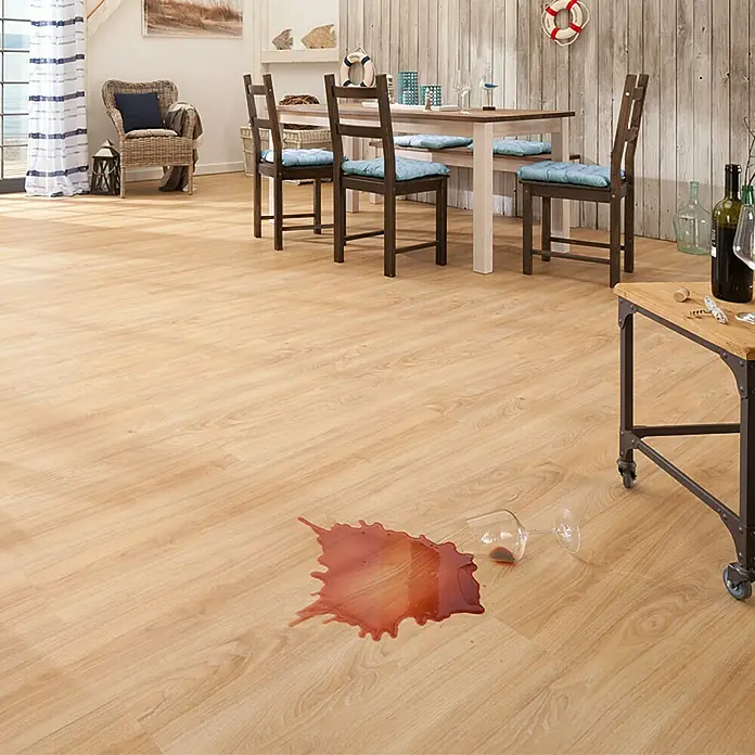 b!design Vinylboden Clic Aspen Eiche - 1.210 x 190 x 5 mm, Landhausdiele - Bild mit einem verschütteten Glas Rotwein auf einem hellen Holzboden, der die Reinigung von Laminatböden hervorhebt.