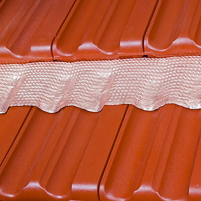 Sarei Moosband - 500 x 20 cm, Selbstklebend - Nahaufnahme von roten Dachziegeln mit einem silberfarbenen, gewellten Firstband, das zwischen den Ziegelreihen verläuft.