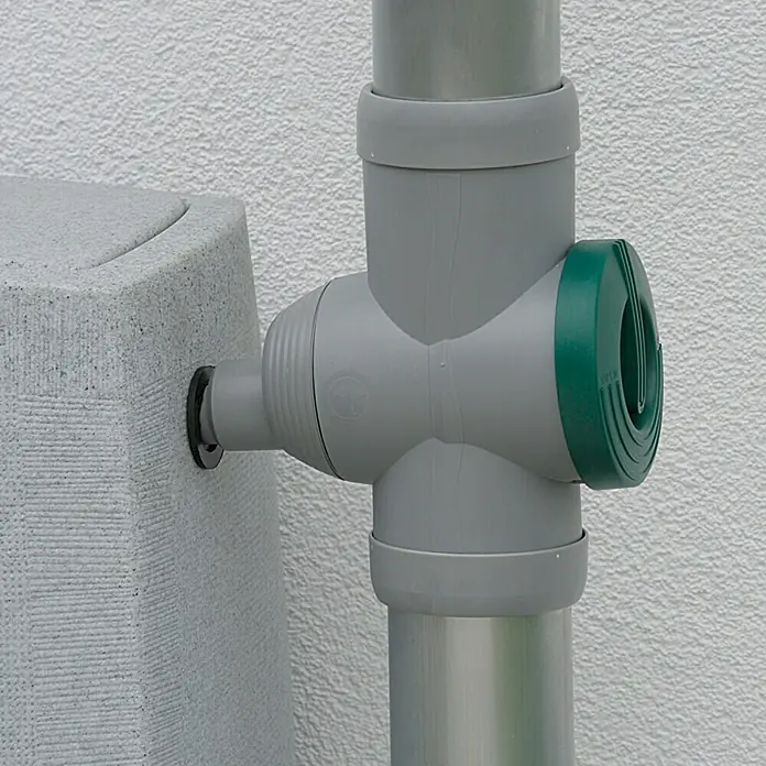 Regensammler Inox - Grau, Grün, Größe Anschluss: 32 mm - Nahaufnahme eines Regenwassersammlers mit einem grauen T-Stück-Verbinder und grünem Auslass vor einer weißen Wand.