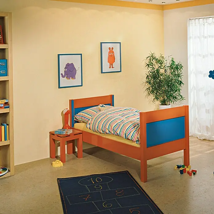 swingcolor Mix Buntlack Acryl zum Mischen lassen - Basismischfarbe 1, Glänzend, 750 ml, Wasserbasiert - Ein Kinderzimmer mit einem orangefarbenen Bett mit blauen Akzenten, einem kleinen Tisch und einem bunten Teppich mit aufgemalten Zahlen.
