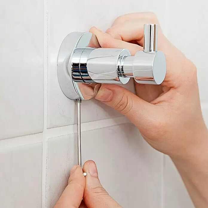 Tesa Toallero de barra LO212 - Ancho: 70 cm - Gancho de pared cromado siendo instalado con un destornillador pequeño.