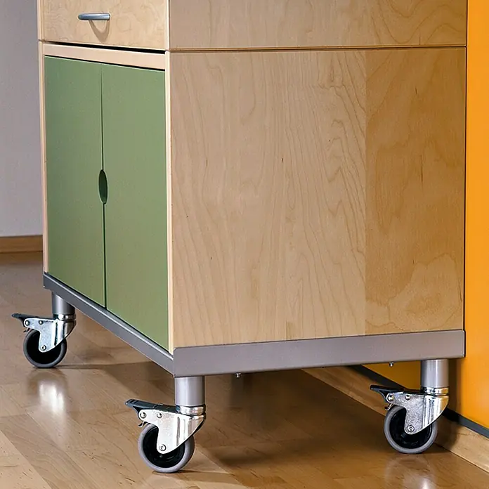 Stabilit Rueda giratoria para equipos - Diámetro ruedas: 50 mm, Capacidad de carga: 45 kg, Material rueda: Goma, Con placa, Casquillo liso - Aparador móvil con puertas verdes y un cajón. El mueble está sobre ruedas y es hecho de madera clara.