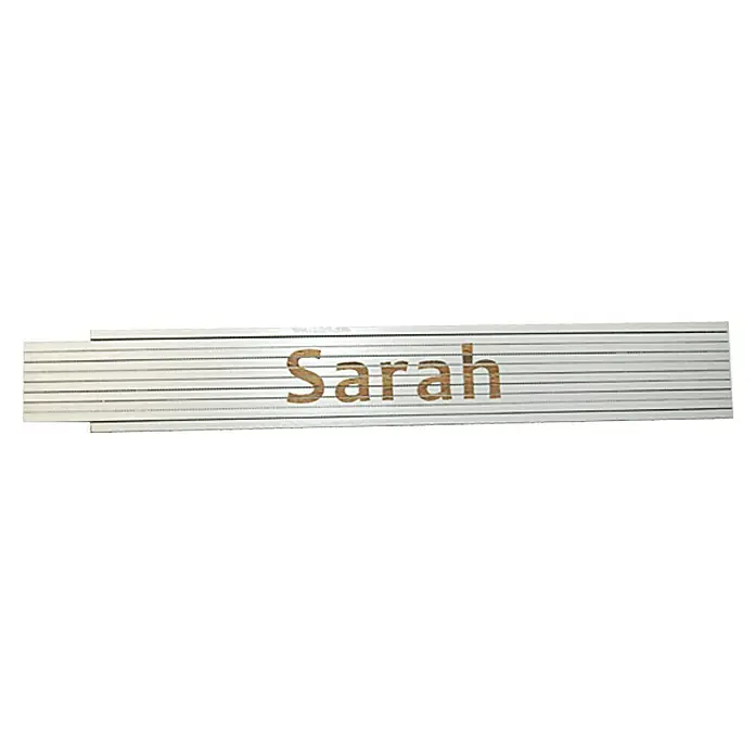 Zollstock - Aufdruck: Sarah, 2 m - Nahaufnahme eines silbernen Namensschildes mit dem Namen "Sarah" in brauner Schrift, ein stilvolles und persönliches Accessoire.