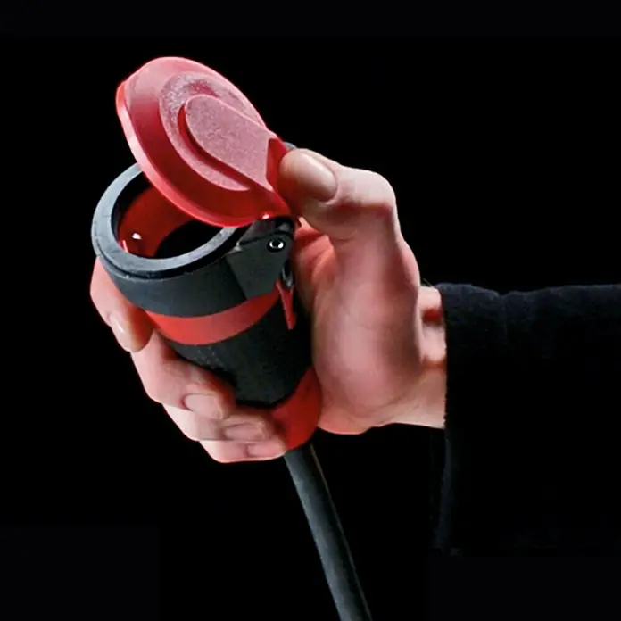 ABL Sursum Gummi-Schutzkontakt-Kupplung SCHUKOultra Pro - Rot/Schwarz, 250 V, IP54 - Das Bild zeigt eine Hand, die einen schwarzen und roten Elektroauto-Ladeanschluss mit geöffneter roter Schutzkappe hält.