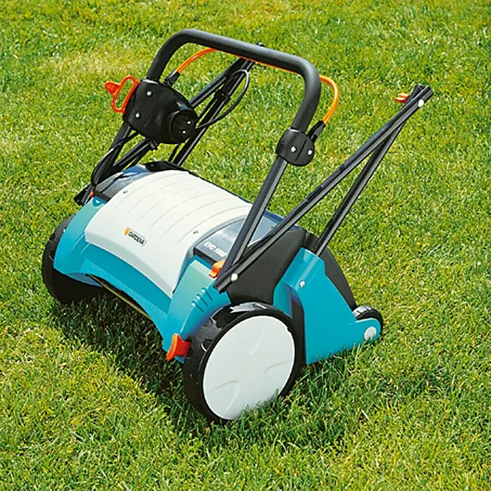 Gardena Elektro-Vertikutierer EVC 1000 - 1.000 W, Arbeitsbreite: 30 cm - Ein blauer Gardena Vertikutierer auf grünem Gras. Das Gerät ist für die Rasenpflege konzipiert.